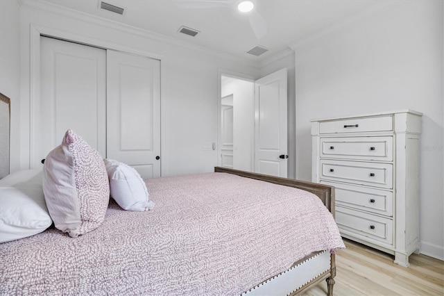 bedroom with light hardwood / wood-style floors, ceiling fan, a closet, and ornamental molding