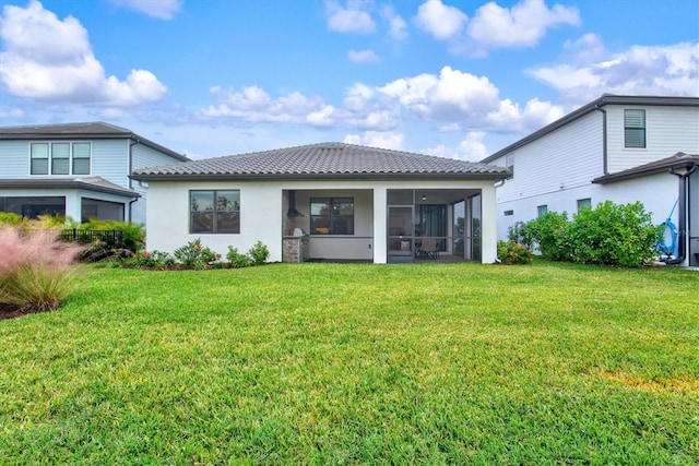 rear view of house with a sunroom and a yard