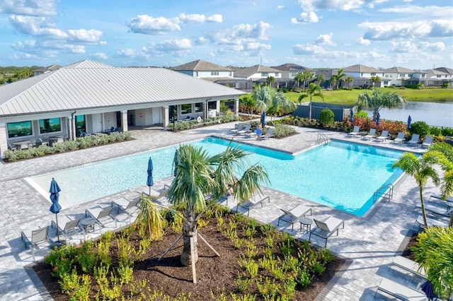 view of pool featuring a patio area and a water view