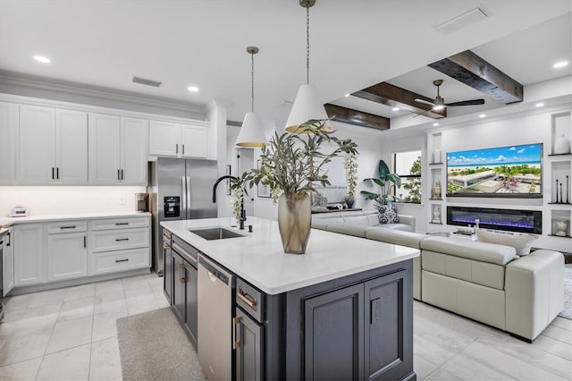 kitchen with white cabinets, hanging light fixtures, sink, a kitchen island with sink, and appliances with stainless steel finishes