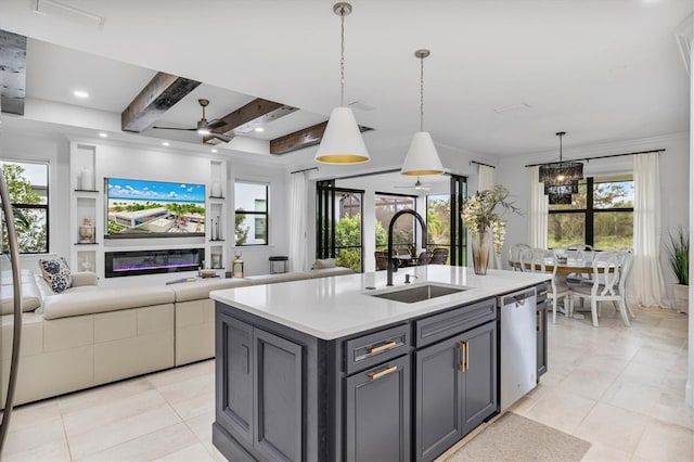 kitchen with stainless steel dishwasher, a center island with sink, hanging light fixtures, and sink