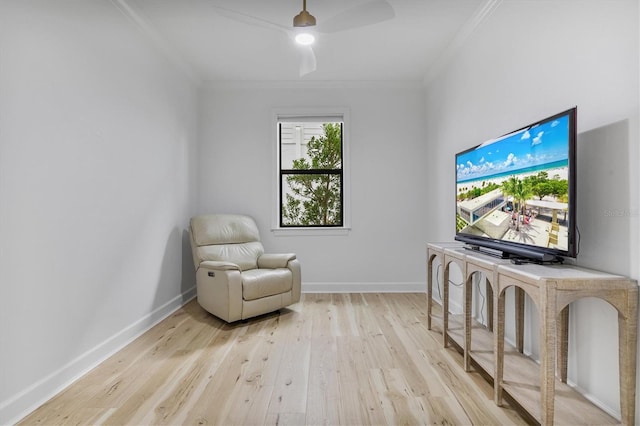 sitting room with light hardwood / wood-style flooring and crown molding