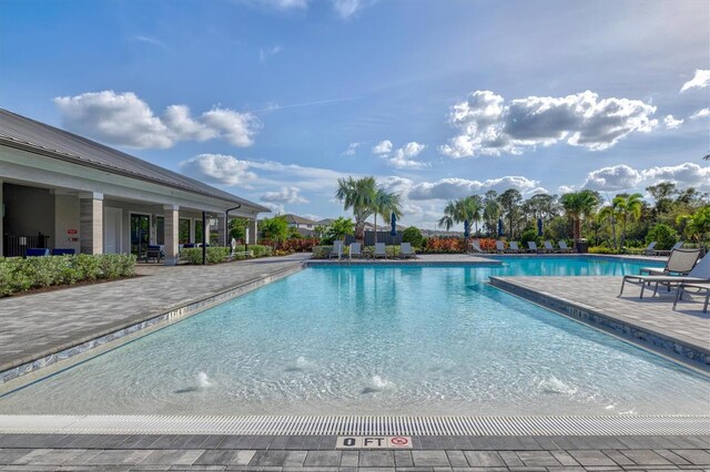 view of swimming pool featuring pool water feature and a patio area