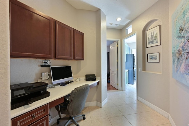 office with light tile patterned floors and built in desk