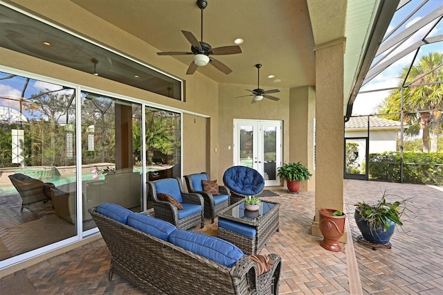 view of patio / terrace with glass enclosure, ceiling fan, french doors, and an outdoor hangout area