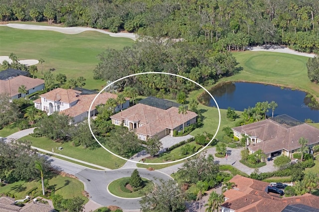 drone / aerial view with view of golf course and a water view