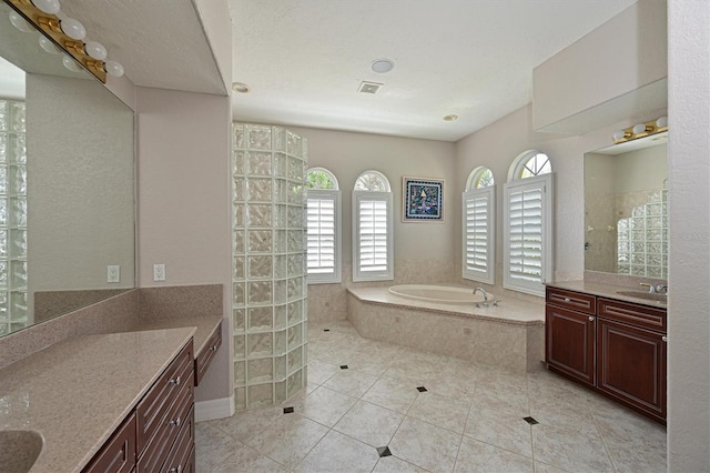 full bathroom with two vanities, a sink, a walk in shower, tile patterned floors, and a bath