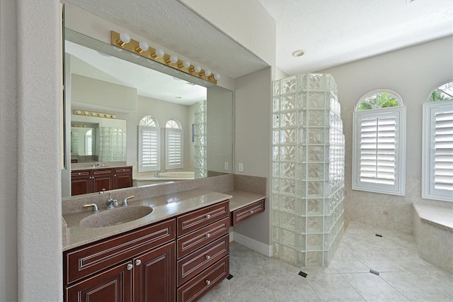 bathroom with a walk in shower, vanity, and tile patterned flooring