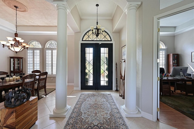 entrance foyer with a chandelier, a healthy amount of sunlight, and ornate columns