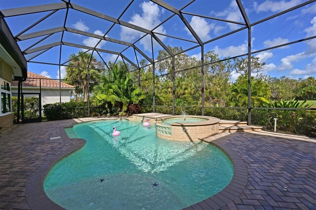 view of pool with a patio area, a lanai, and a pool with connected hot tub