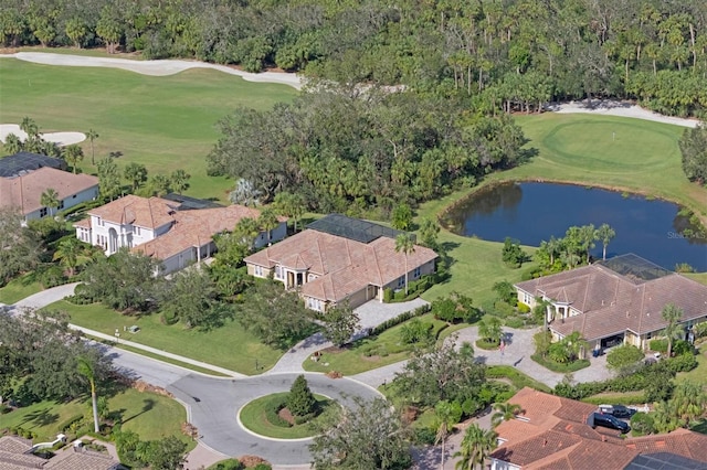 drone / aerial view with view of golf course and a water view