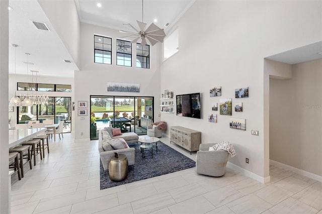 living room featuring ceiling fan, crown molding, and a high ceiling