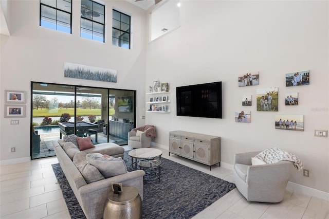 living room with light tile patterned floors and a high ceiling