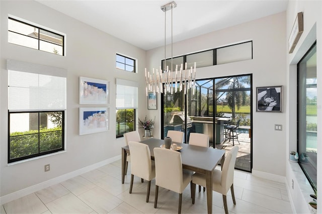 dining space with light tile patterned floors, a wealth of natural light, and a notable chandelier