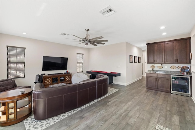 living room featuring hardwood / wood-style floors, beverage cooler, and ceiling fan