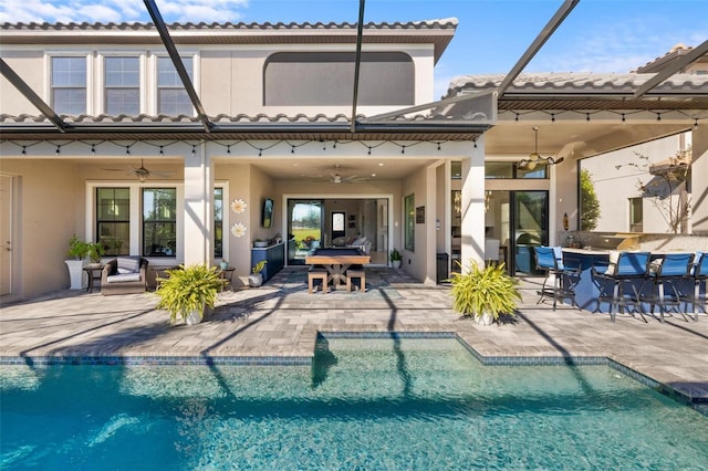 rear view of house featuring ceiling fan and a patio area