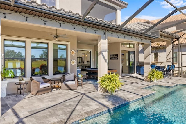 back of property with a lanai, ceiling fan, and a patio