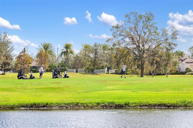 view of community with a lawn and a water view