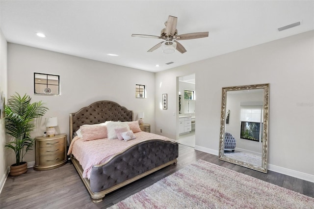 bedroom featuring ceiling fan, ensuite bathroom, and dark wood-type flooring