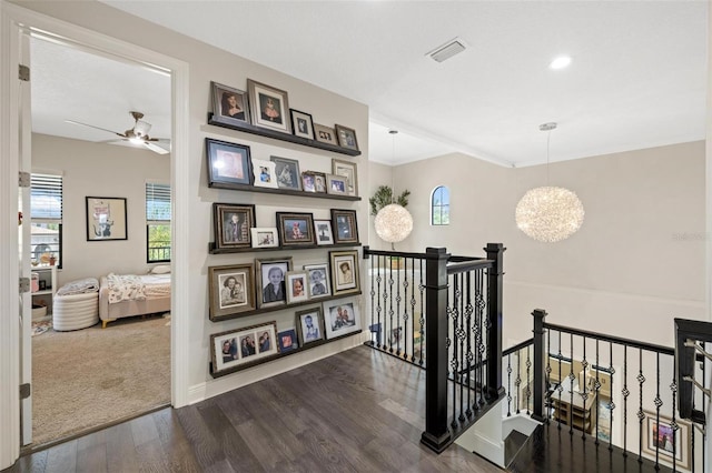 hall with wood-type flooring and an inviting chandelier