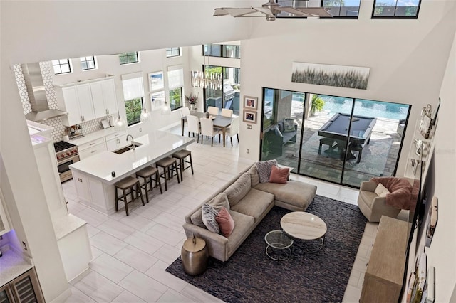 living room featuring a towering ceiling and sink