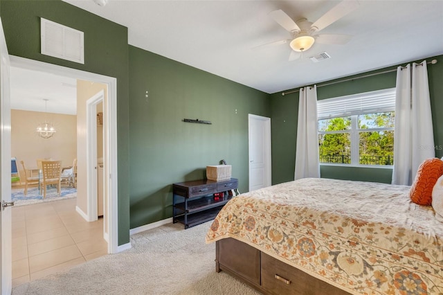 bedroom featuring ceiling fan with notable chandelier and light carpet