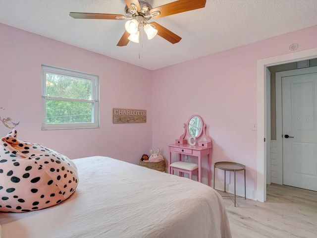 bedroom featuring ceiling fan, a textured ceiling, and light wood-type flooring