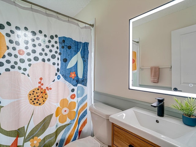 bathroom with toilet, a shower with curtain, vanity, and a textured ceiling