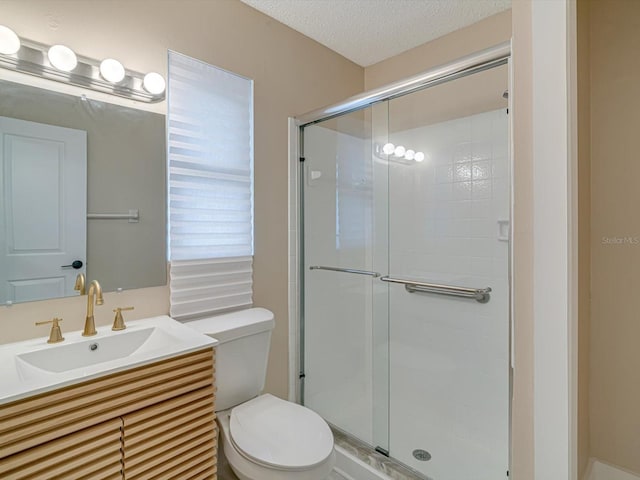 bathroom featuring an enclosed shower, vanity, a textured ceiling, and toilet