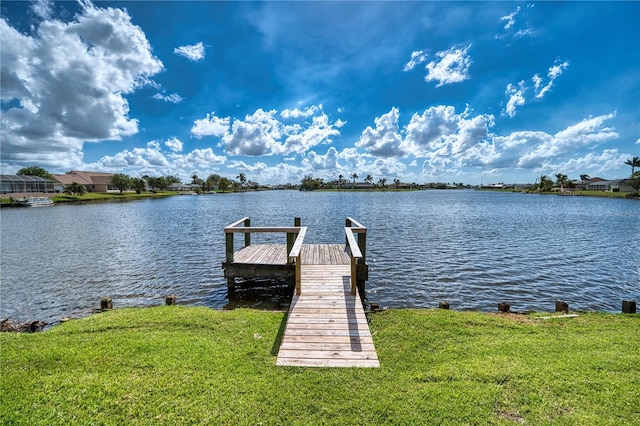 view of dock featuring a lawn and a water view