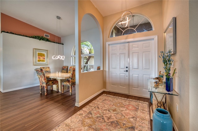 foyer entrance with high vaulted ceiling and dark hardwood / wood-style flooring