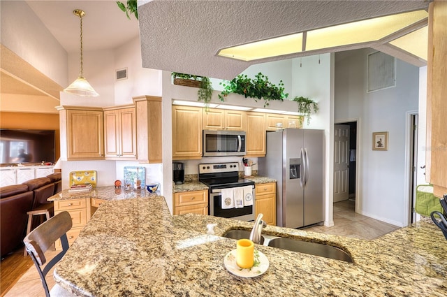 kitchen featuring kitchen peninsula, a textured ceiling, sink, high vaulted ceiling, and appliances with stainless steel finishes