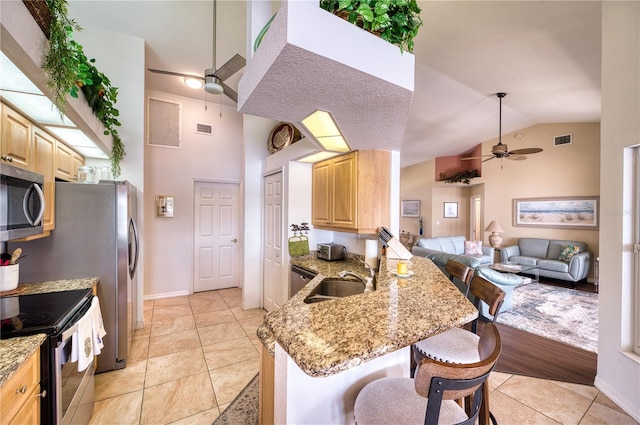 kitchen featuring stainless steel appliances, sink, kitchen peninsula, a kitchen breakfast bar, and light wood-type flooring