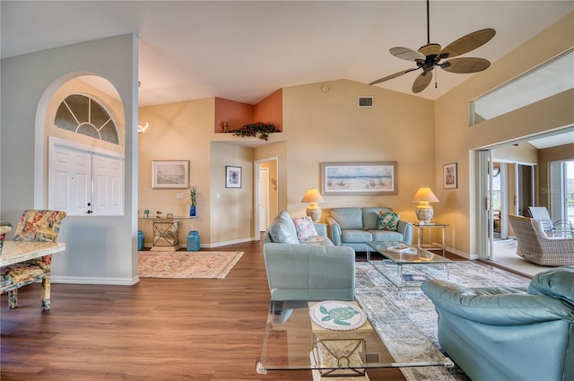 living room with ceiling fan, wood-type flooring, and vaulted ceiling