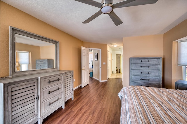 bedroom featuring dark wood-type flooring, connected bathroom, ceiling fan, and a textured ceiling