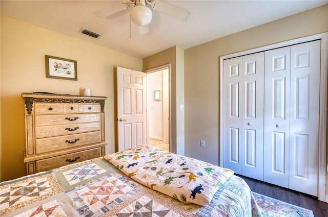 bedroom featuring dark hardwood / wood-style flooring, ceiling fan, and a closet