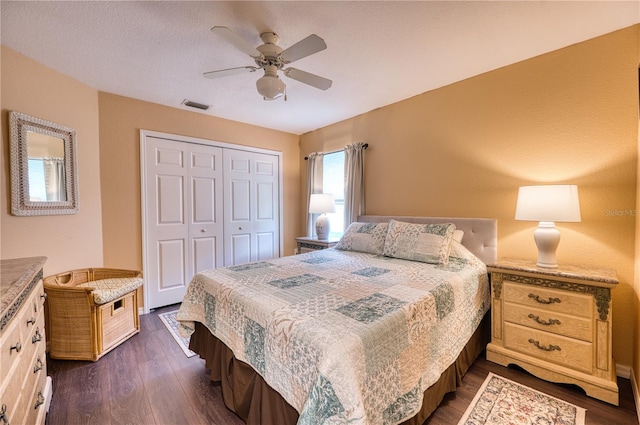 bedroom featuring ceiling fan, a textured ceiling, a closet, and dark hardwood / wood-style flooring