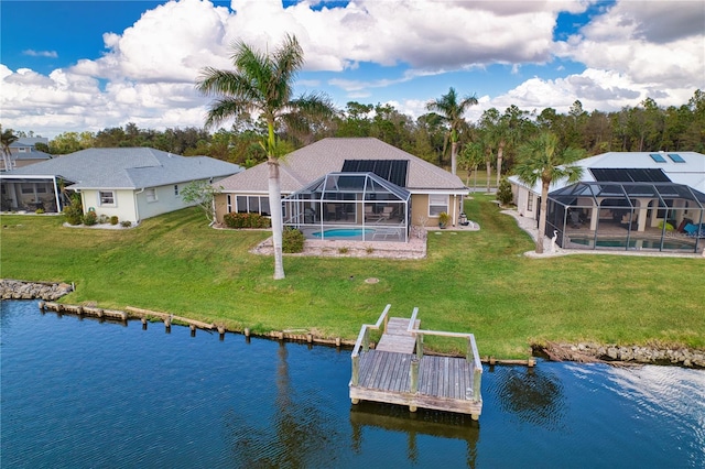 back of house with a lanai, a water view, and a lawn