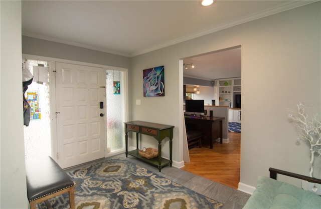 foyer entrance with ornamental molding and hardwood / wood-style flooring