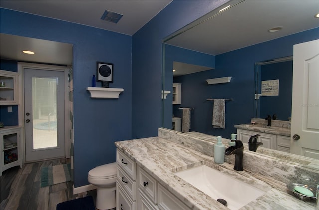 bathroom featuring hardwood / wood-style floors, vanity, and toilet