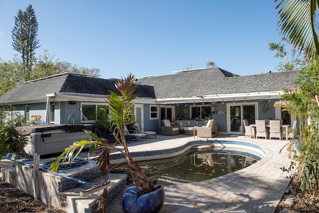 back of property featuring a hot tub, an outdoor hangout area, and a patio area