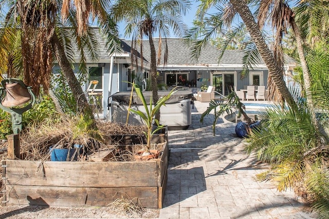 view of front facade with a pool with hot tub and a patio area