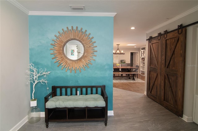 hallway featuring a barn door, hardwood / wood-style flooring, and ornamental molding