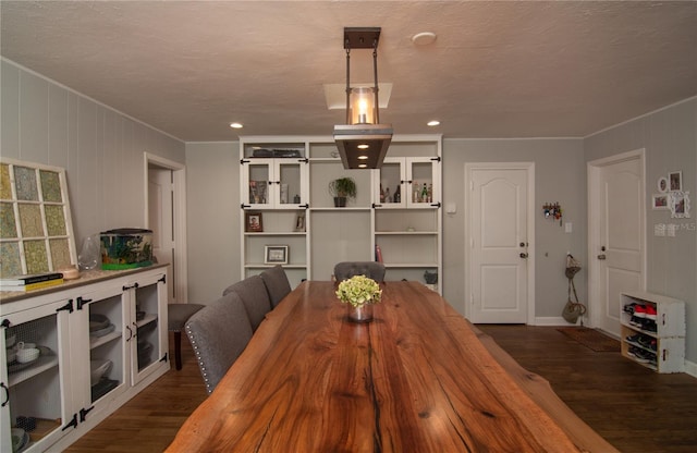 dining room featuring a textured ceiling, dark hardwood / wood-style floors, and crown molding