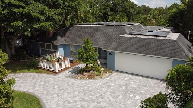 view of front of home with a garage and solar panels