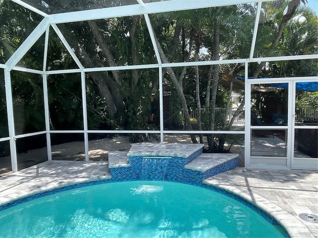 view of swimming pool featuring a patio, glass enclosure, and pool water feature