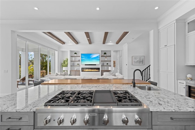 kitchen featuring gray cabinets, white cabinetry, sink, and light stone counters