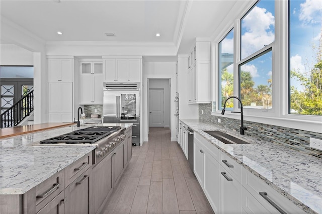 kitchen featuring white cabinetry, stainless steel appliances, sink, and backsplash