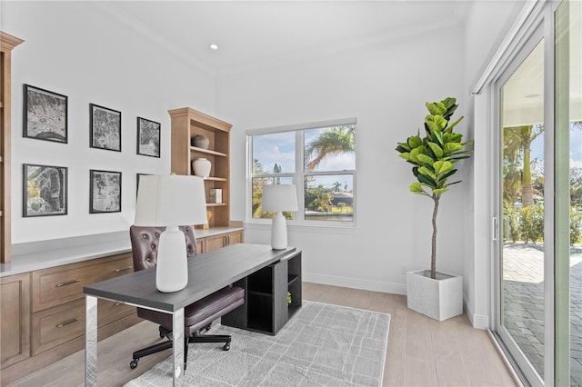 office space featuring light wood-type flooring and crown molding