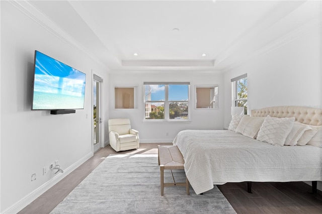 bedroom with hardwood / wood-style flooring and a raised ceiling